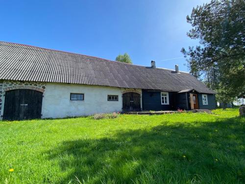an old house with a grass field in front of it at Farmhouseinn1923 