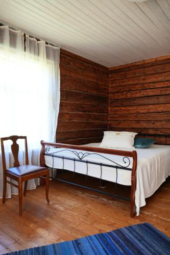 a bedroom with a bed and a chair and a window at Farmhouseinn1923 