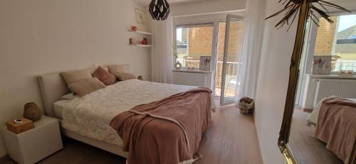 a bedroom with a bed and a large mirror at Evasion mer à Ostende in Ostend