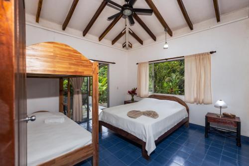 a bedroom with two beds and a window at Casa Cedro - Portasol Vacation Rentals in Matapalo
