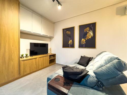 a living room with a couch and a tv at Apto/Flat Moderno Perto da Unifebe e shoppings in Brusque