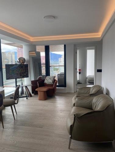 a living room with a couch and chairs and a tv at Brand New Modern 2 BR Condo in Heart of Downtown Vancouver in Vancouver