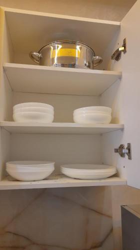 a kitchen shelf with plates and a pot on top at Azur et Atlas in Saïdia