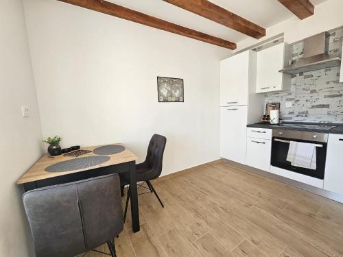 a kitchen with a table and chairs in a room at Apartment Lotta in Sali