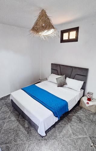 a bedroom with a large bed with a blue blanket at Beachside Retreat in Imi ouadar in Agadir