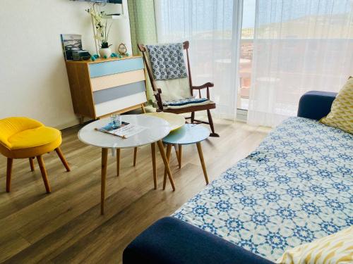 un salon avec un canapé, une table et des chaises dans l'établissement La Timonerie - La Caraque 35, vue mer et dunes classé 2 étoiles, à Fort-Mahon-Plage