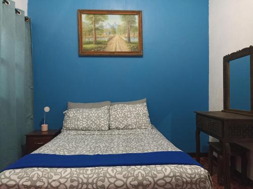 a blue bedroom with a bed and a mirror at Casa Rincón in San Cristóbal de Las Casas