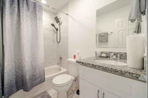 a white bathroom with a toilet and a sink at The Divine 3 - Townhome with AC, WiFi in Beautiful Houston in Houston