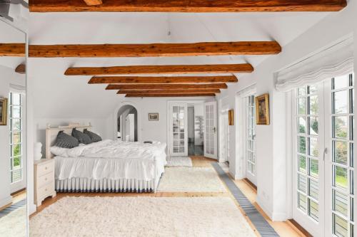 a bedroom with white walls and a bed and windows at Copenhagen Denmark by the Sea Villa Solrd Strand in Solrød Strand