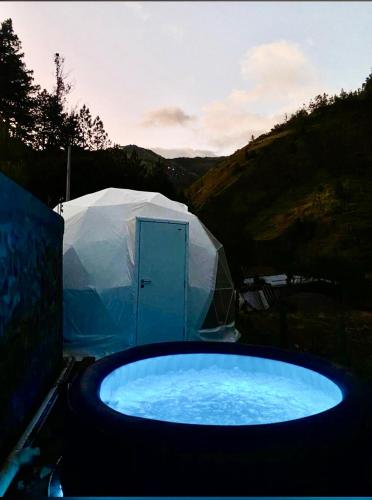 a hot tub in a field with a tent at Casa Cram in Juivi