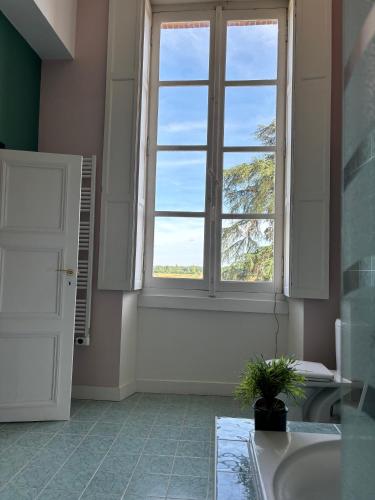 La salle de bains est pourvue d'une grande fenêtre et d'un lavabo. dans l'établissement Chambre d'hôte double 2 au Château Lavalade, à Castelsarrasin