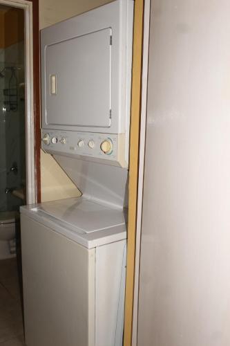 a microwave sitting on top of a refrigerator at Artist Place Kensington 2BR New Kingston in New Kingston