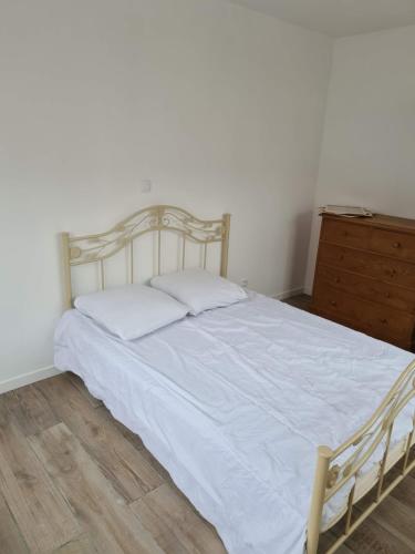 une chambre avec un lit blanc et une commode dans l'établissement La maison du bonheur, au Crotoy