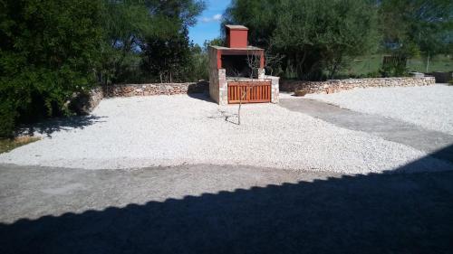 a small brick oven in a gravel yard at Olmedo Casa Vacanze in Olmedo