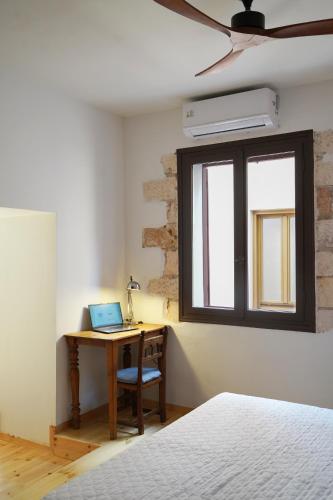 a bedroom with a desk with a laptop on it at Venetian Palace Chania in Chania Town