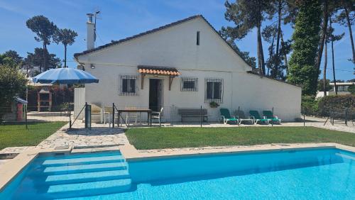 a house with a swimming pool in front of a house at Casinha; Piscina/ Praia/ Lisboa in Aroeira