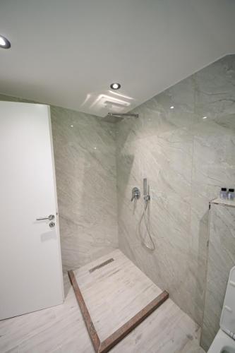 a bathroom with a shower with a hose in it at Endri Guest House 