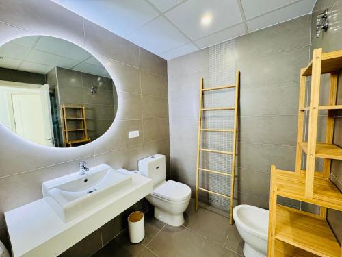 a bathroom with a sink and a toilet and a mirror at Althaia Hills - Precioso adosado con terraza panorámica al mar y montaña in Altea