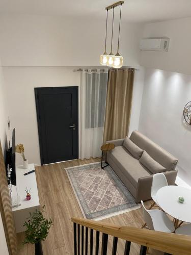a living room with a couch and a table at Riara Home in Vlorë