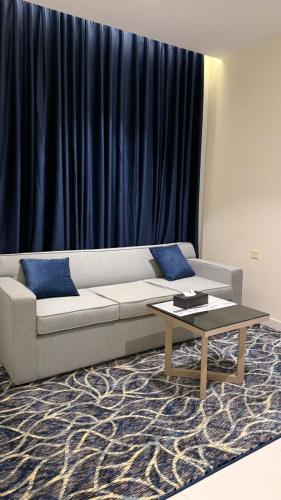 a living room with a couch and a coffee table at شقق تولين الذهبية المخدومة in Al Baha