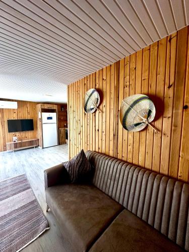 a living room with a brown couch and wooden walls at Kandybos Eco Farm Village in Kas