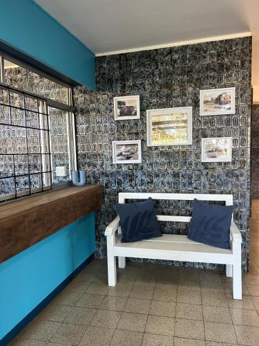 a white bench in a room with a blue wall at Coastal Bliss Retreat Peacehaven 207 in Scottburgh