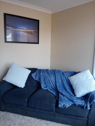 a blue couch in a living room with two pillows at Christian couples retreat, pet friendly BnB in Dawesville