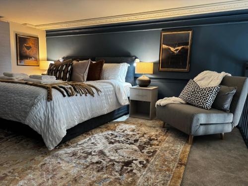 une chambre avec un grand lit et une chaise dans l'établissement Manhattan-Style Chic Loft, Sleeps 5, Heart of Leeds, à Central Station