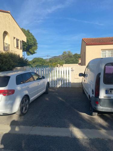 two cars parked in a parking lot next to a house at Maison 4 personnes Sorède in Sorède