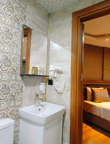 a bathroom with a sink and a bed in a room at Vizyon Park Otel in Urfa