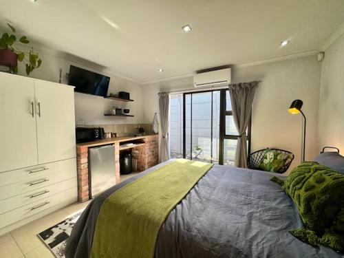 a bedroom with a bed and a large window at The Courtyard in Vosburg