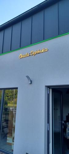 a sign on the side of a building at Dębówka - apartament rodzinny in Wilcze