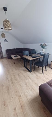 a living room with a couch and a table at Dębówka - apartament rodzinny in Wilcze