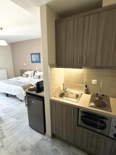 a kitchen with a sink and a bed in a room at Vesperi Studios & Apartments in Rethymno Town