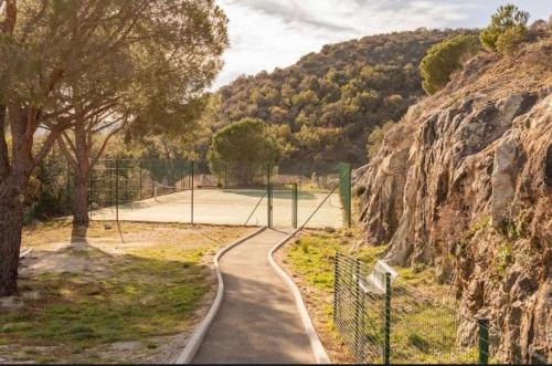une route sinueuse menant à un court de tennis sur une colline dans l'établissement Maison Jobèr, au Plan-de-la-Tour