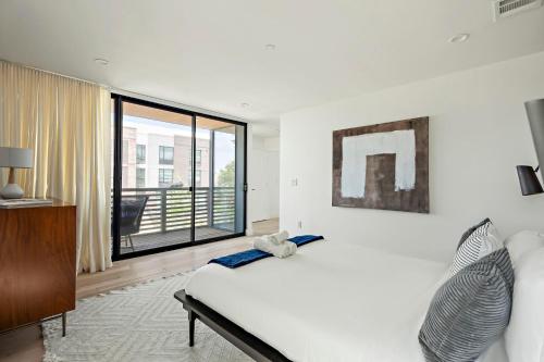 a bedroom with a bed and a large window at Rooftop Deck, DT City Views, Modern Eastside Oasis in Austin