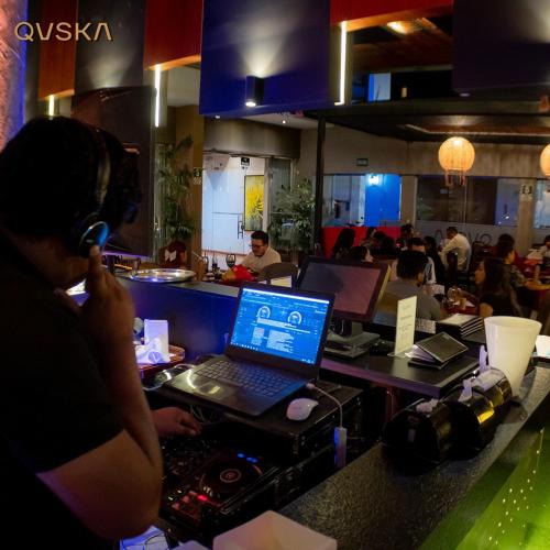a person with headphones and a laptop on a table in a restaurant at Dorado Hotel Boutique - Tacna in Tacna