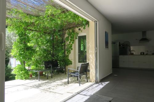 une terrasse avec une chaise, une table et un arbre dans l'établissement L'embellie, à Châteaurenard
