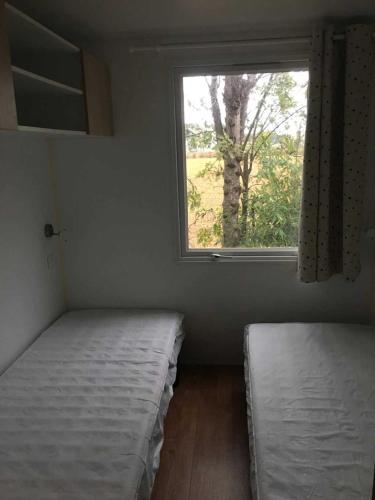 deux lits dans une chambre avec une fenêtre dans l'établissement Camping 4 étoiles - Piscine - ccbahea, à Lansargues