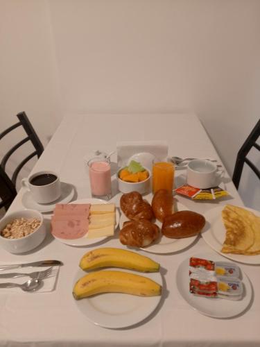 a table topped with plates of breakfast foods and drinks at El Quetzal MachuPicchu in Machu Picchu