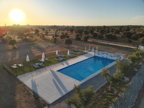 an overhead view of a swimming pool with the sunset at Herdadinha in Vimieiro