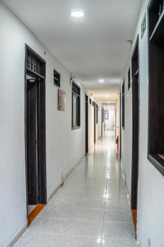 an empty hallway with white walls and black doors at Santa Helena Suite in Acacías
