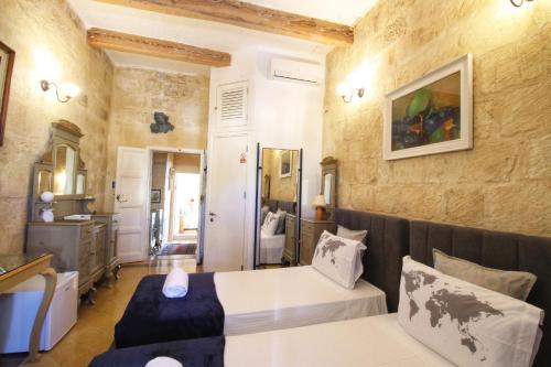 a bedroom with a bed and a couch in a room at The Knight - Experiential Heritage Home at Birgu Square in Birgu