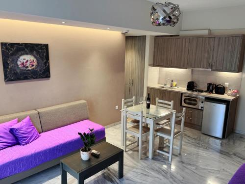a living room with a purple couch and a table at Vesperi Studios & Apartments in Rethymno Town