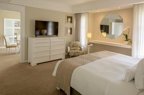 a bedroom with a bed and a dresser with a television at Bourbon Resort Atibaia in Atibaia