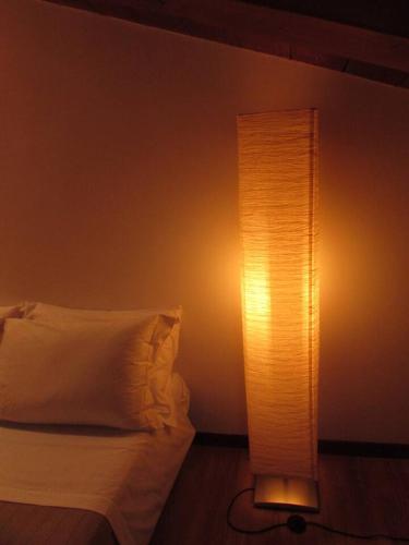a lamp next to a bed with a white pillow at centralatticmatera in Matera