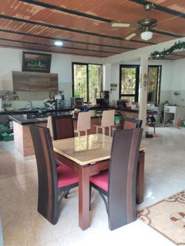 a dining room with a wooden table and chairs at La Casa De Los Sueños Colombia Hostel Campestre Temático Ancestral in Ibagué