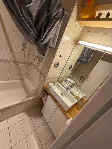 a small bathroom with a sink and a tub at LOFT Vanelyn RETRO Central Terrace in Wiesbaden