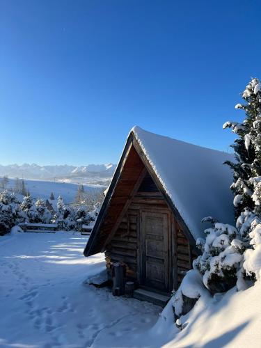 a log cabin with snow on the roof at Zakątek u Ili in Rzepiska