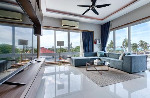 a living room with blue furniture and large windows at Surisa Seaview Pool Villas in Chaweng Noi Beach